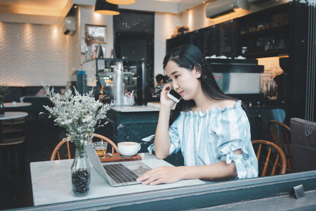Asian woman using smart phone in the coffee shop.の写真素材