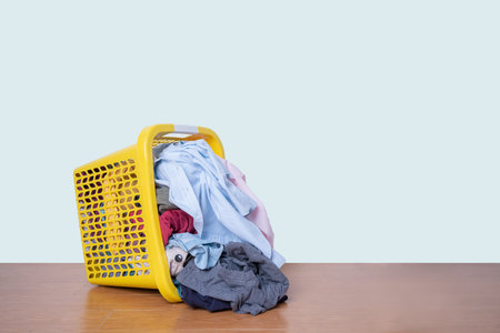 Clothes in a basket with dirty laundry on floor with clipping path.の写真素材
