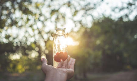 Woman hand giving bottle with heart shape,Valentine concept.の写真素材