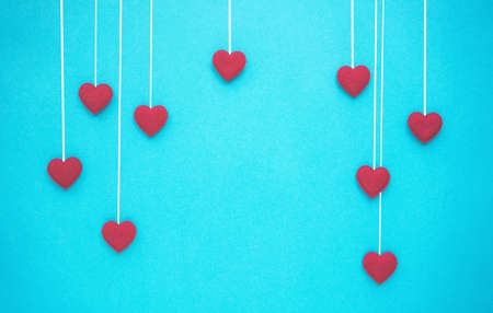 Red hearts. Valentine's Day background with hanging hearts on blue background.の写真素材