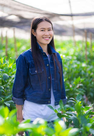 Portrait of asian female farmer smiling at the camera in a farm.の写真素材