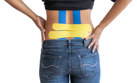 Back pain, kinesiology taping on woman back on white background with clipping path.の写真素材