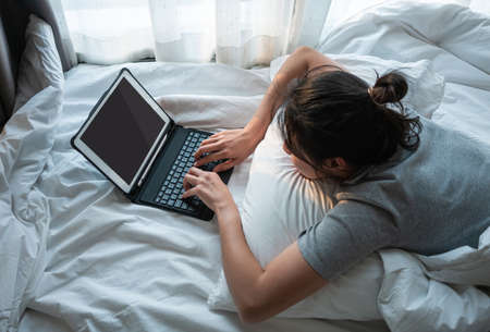 Young woman Thoughtful sit on foor in bedroom alone at home.の写真素材