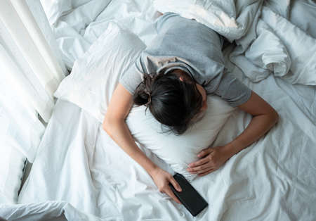 Young woman Thoughtful sit on foor in bedroom alone at home.の写真素材