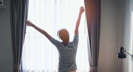 Young woman Thoughtful sit on foor in bedroom alone at home.の写真素材
