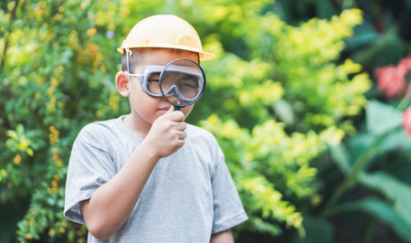 Asian kid looking at leaves and holding magnifying glass for explore.の写真素材