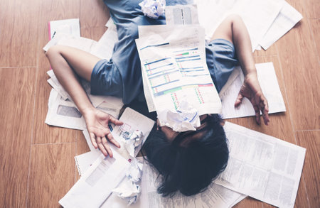Top view of stressed young asian woman worry about the debts and bills.の写真素材