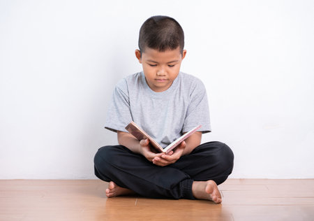 Asian boy reading a book.