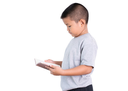 Asian boy child reading a book in home.He standing with a book.の写真素材