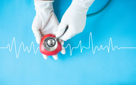 Doctor hands with medical gloves holding red heart, heart health, donation, world heart day, saving...
