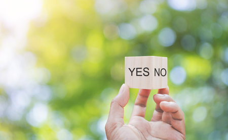 Yes or no decision, Hand holding wooden blocks with and word Yes and No.の写真素材
