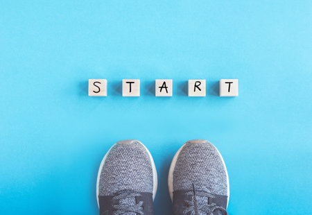 Sneakers and word Start on Wooden block on blue background, Start up, start to success or Business Challenge.の写真素材