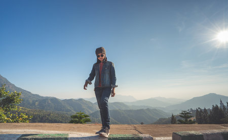Happy woman standing  relaxed beside the road on a mountain of thailand.の写真素材