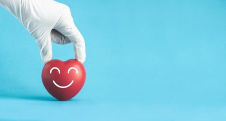 Doctor hands with medical gloves holding red heart, heart health, donation, world heart day, saving life.の写真素材