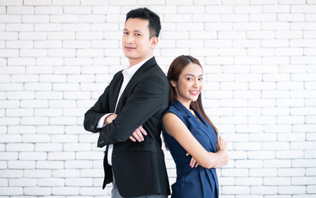 Concept of partnership in business. Portrait of smiling  young man and woman business partners looking at camera on white background.の写真素材
