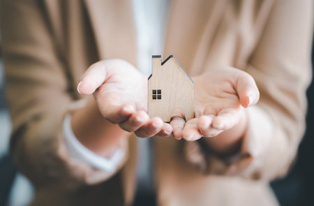 Female holding a house model for family home.
Real estate agent offer house.の写真素材