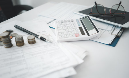 Stacked of Coins with calculator,tax form,glasses and pen ,Income Tax Raise Concept.の写真素材