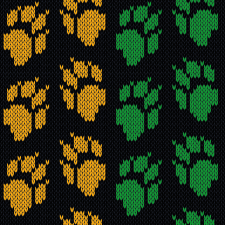 Cat paw tracks in orange and green colors on the black background, knitting seamless pattern as a fabric texture or handmade designのイラスト素材
