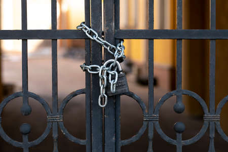 Black iron gate with rust closed on padlock with chains, Perimeter securityの写真素材