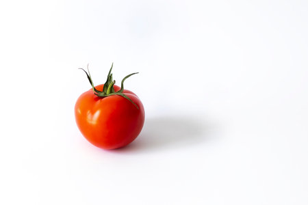 One red tomato on white background, isolated vegetable