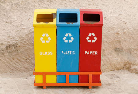 Three colored waste bins, with signs of old age and rust, for sorting waste - protecting the environmentの写真素材