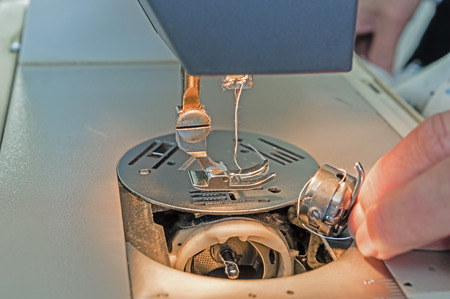 Sewing needle in a sewing machine. Threading a needle in a sewing machineの写真素材