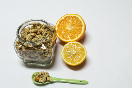 Healty food with bowel and spoon of cereals. Orange and lemon are next to, cut in half, iIsolated on white background.の写真素材