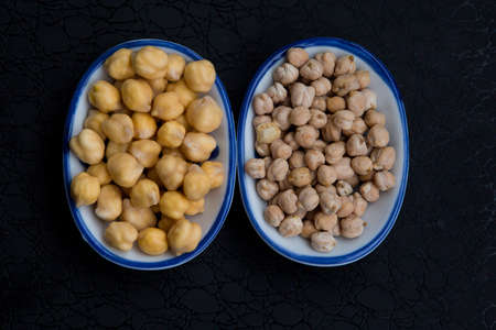 dry and soaked chickpeas close up on a dark background. High quality photoの写真素材