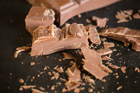 pieces of chocolate and chocolate chips on a dark background.