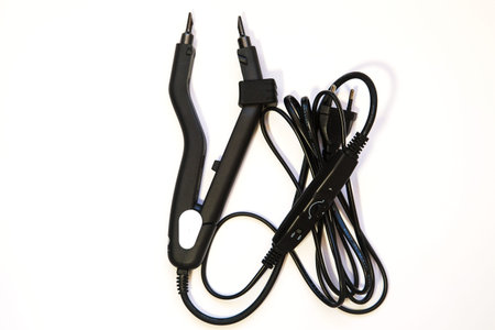 black hair extension tongs on a white background. High quality photo