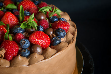 chocolate cake decorated with strawberries, raspberries and blueberries, top viewの写真素材