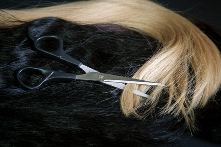 natural hair of different colors with scissors and comb. concept of hair care and hairdressing servicesの写真素材