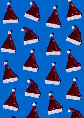 Red santa clause hat with white fur against blue background. Minimnal christmas and new year gift...