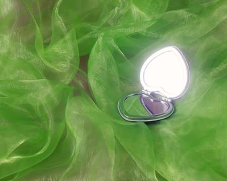 Heart shape mirror on green wave tulle fabric. Retro St. Valentines Day concept. Flat lay minimal greeting card.の写真素材