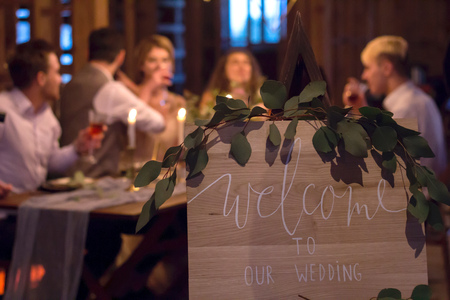 Wedding feast. Guests sit at festively decorated table. Evening candlelight.の写真素材
