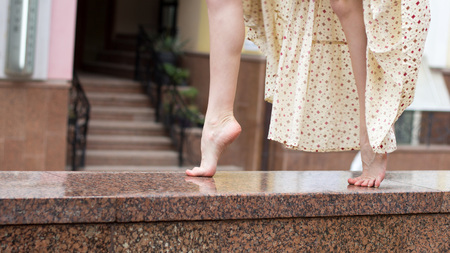 Sexy legs of young dancing girl on a marble parapet. Close up.の写真素材
