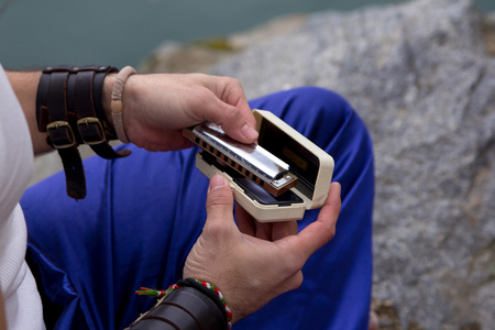 Man takes out the harmonic from the case. Hands Close-up.の写真素材
