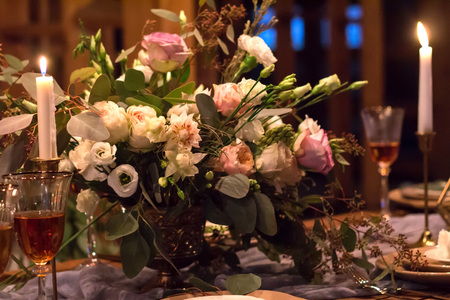 Laid Table By wedding banquet in a wooden barn. Candles and bouquet. Vintage Style.の写真素材