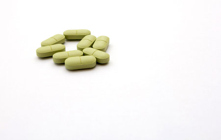 Green pills on a white background. Close-up.