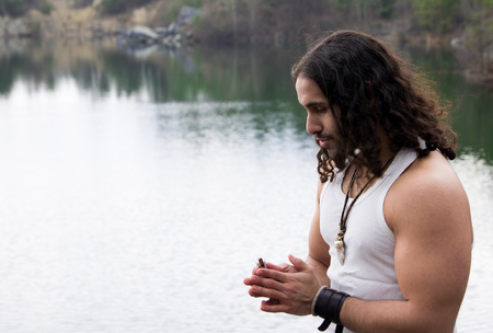 Young Man plays the harmonica alone outdoor Travel Lifestyle concept with lake.の写真素材