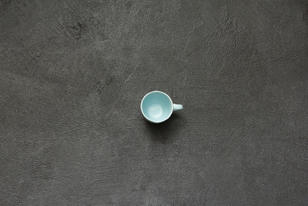 Blue porcelain empty coffee cup on a black stone background. Empty cup top view.の写真素材