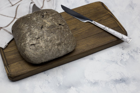 Loaf of bread on cutting board. Whole grain bread on the kitchen table.の写真素材