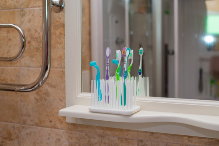 Colorful toothbrushes in glass. Closeup. Isolated on white backgroundの写真素材