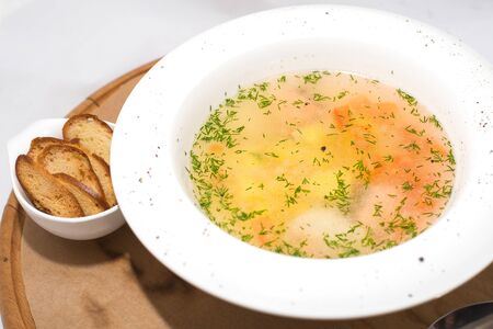 Vegetable soup with dill in a white plate on a tree on white backgroundの写真素材