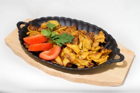 potatoes fried meat in a frying pan on a tree onion on a white backgroundの写真素材