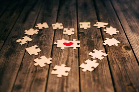 Red heart puzzle together. Concept of Valentine's day. Selective focus. Love. Divorce. Broken heart. The reunion of the lovers. How to find your soul mate in love?の写真素材