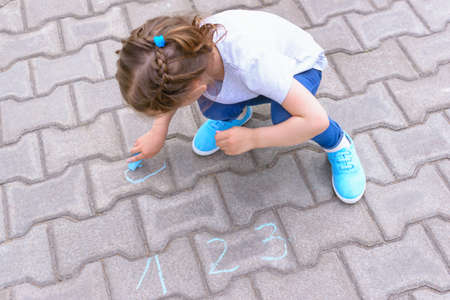 happy little girl draws with chalk. Holidays. Childhoodの写真素材