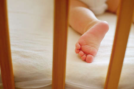 Infant baby is sleeping in his crib. Importance of sleep for babies. Sleep mode babies 5 monthsの写真素材