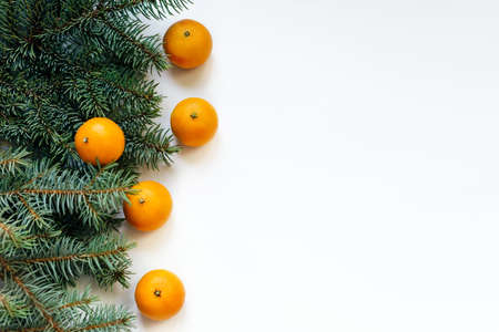 Christmas New Year composition with tangerines and green fir tree branches on an isolated white background. Holiday decoration.の写真素材