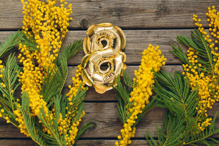 Mimosa Branch Golden Figure Balloon 8 Gift Card Wooden Background. Banner for March 8. Women's Day. Color 2021の写真素材